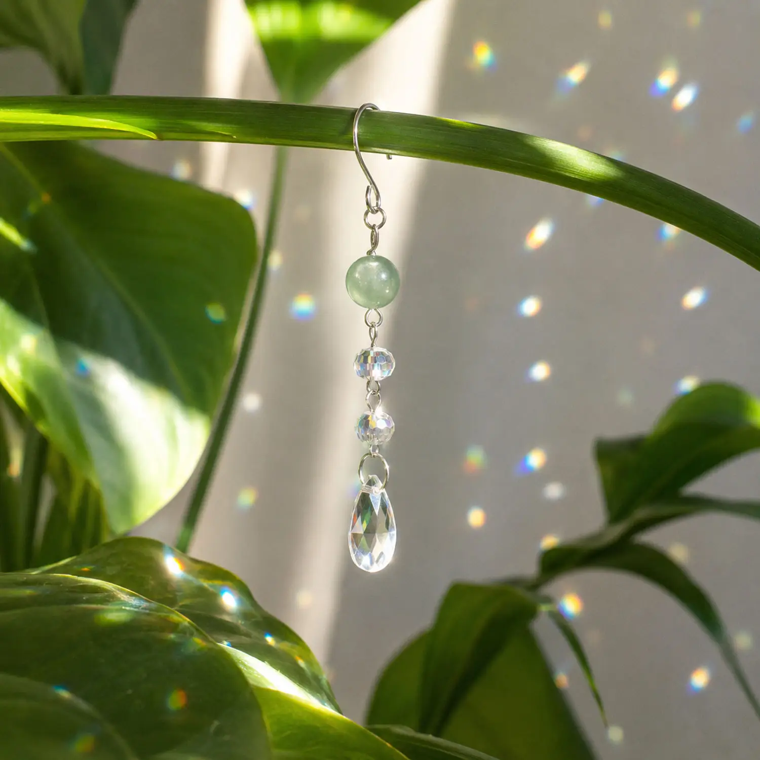Mini suncatcher anti-stress en aventurine verte, fabriqué à la main. Suspendu près d'une fenêtre, il diffuse de magnifiques reflets arc-en-ciel dès que le soleil apparaît.
