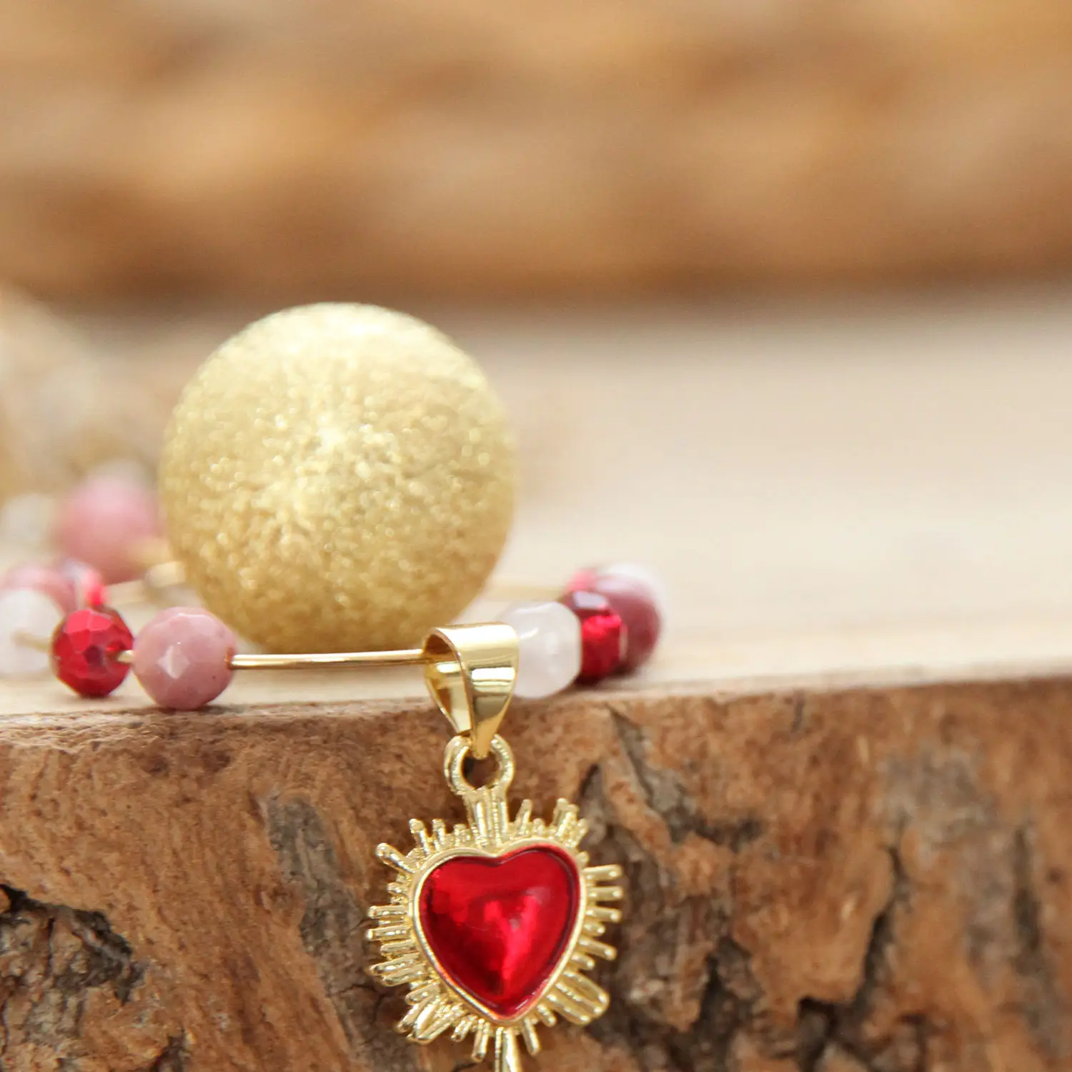 Détail du bola Mon Amour avec pierres naturelles roses et perles rouges à facettes.